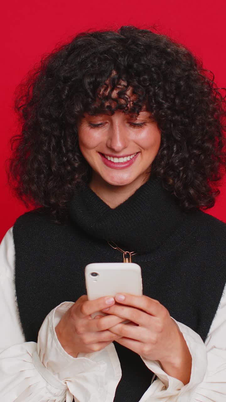 Donna che usa lo smartphone per scrivere un nuovo post sul web, navigare un messaggio, essere dipendente dalle reti sociali, giocare a giochi.