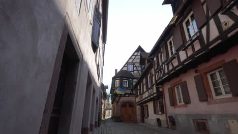 Leere-Straße-In-Kaysersberg,-Mit-Ukrainischer-Flagge,-Die-An-Einem-Fachwerkhaus-Hängt