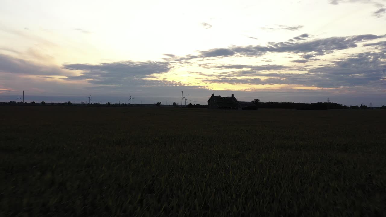 casa abbandonata nel mezzo del campo di grano al tramonto basso volo in avvicinamento