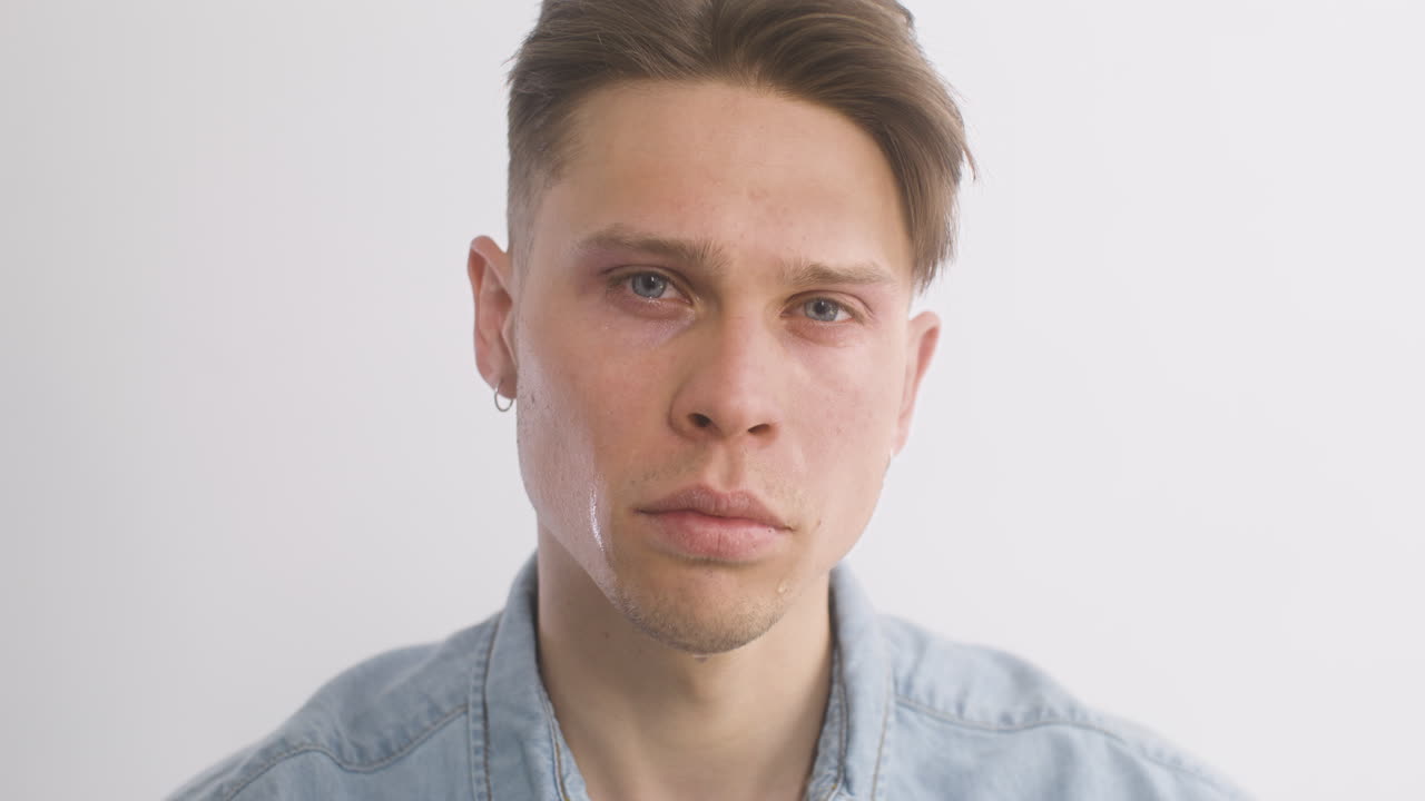 hombre rubio triste en camisa de mezclilla, llorando