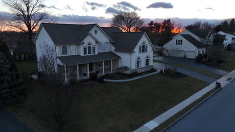 aerial establishing shot of large american home during winter sunset