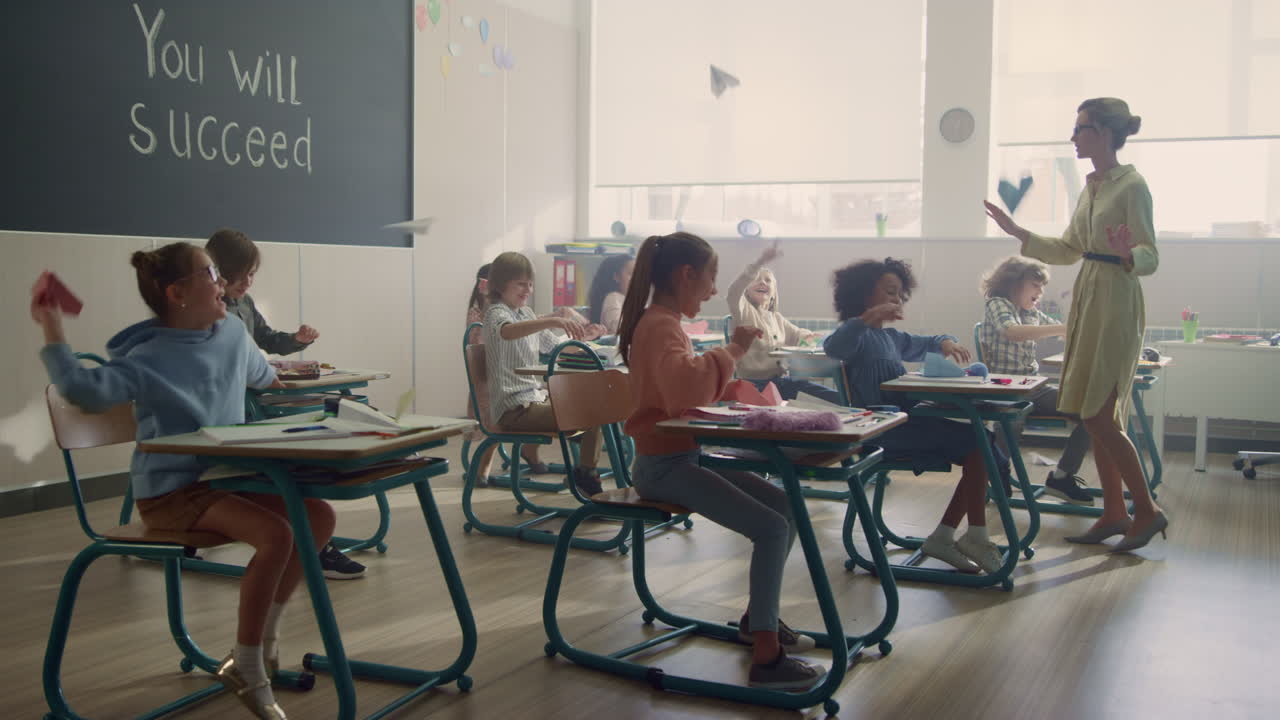 Students sitting at desks in classroom. Pupils playing with paper planes
