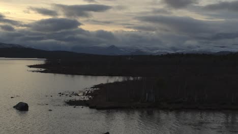 dramatic sunset with overcast over mountains and lake in sweden