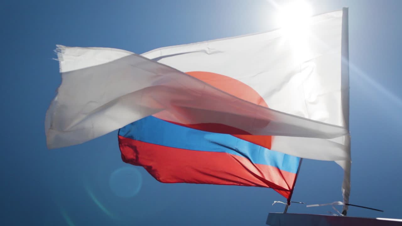 Russiske og japanske flagg blafrer i vinden sammen
