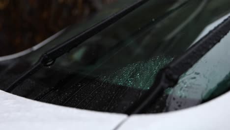 a video of a car's windshield wipers moving rain droplets out of the way during a rain shower.