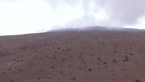 Luftaufnahme-Der-Vulkanebenen-In-Cotopaxi-Mit-Einem-Im-Nebel-Verborgenen-Vulkan