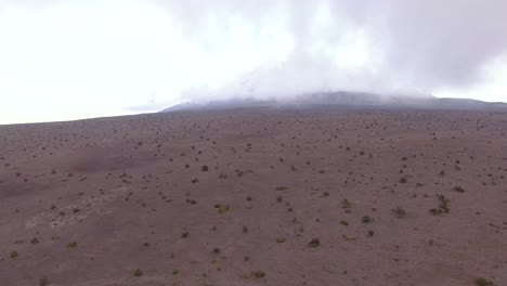 vista aérea de las llanuras volcánicas en cotopaxi con un volcán escondido en la niebla