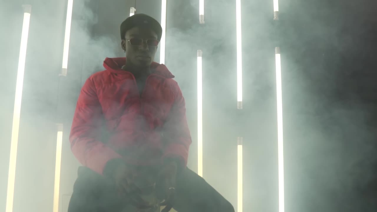 hombre afroamericano sentado detrás de las lámparas-ampollas