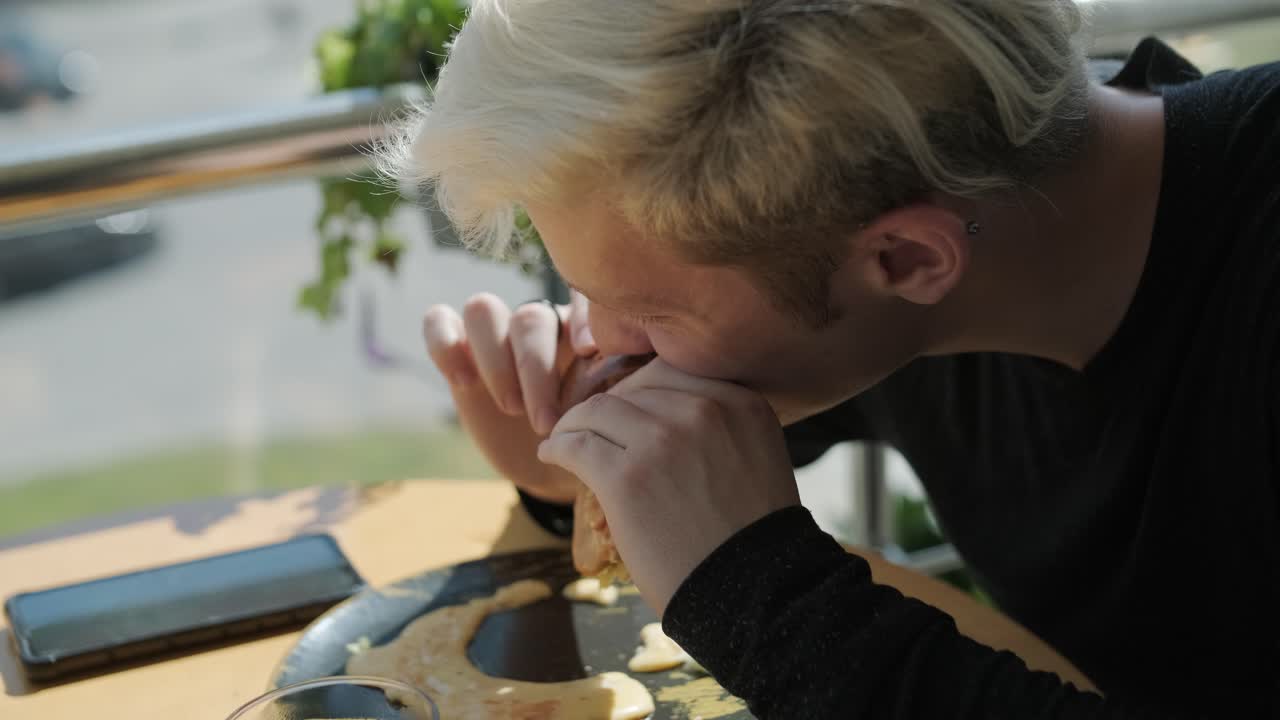 레스토랑에서 햄버거를 먹는 남자