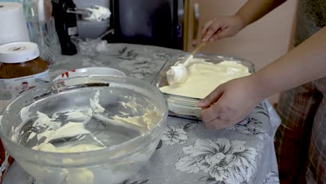 crema batida casera que se alisa a través de los dedos de las manos con una espátula