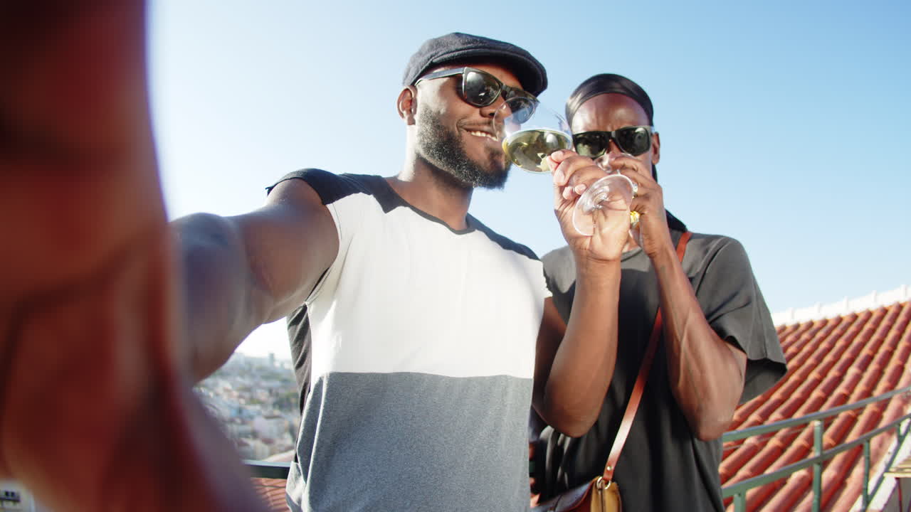 옥상에서 카메라로 와인을 마시는 행복한 게이 커플의 pov