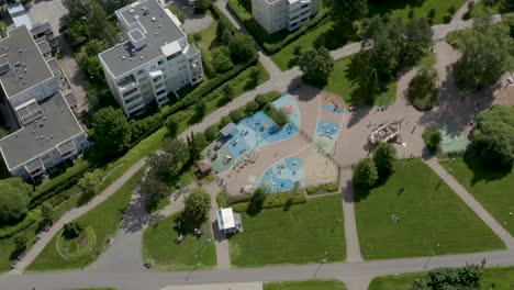 Vista-Aérea-De-Arriba-Hacia-Abajo-De-Un-Colorido-Parque-Infantil-En-Un-Parque,-Finlandia