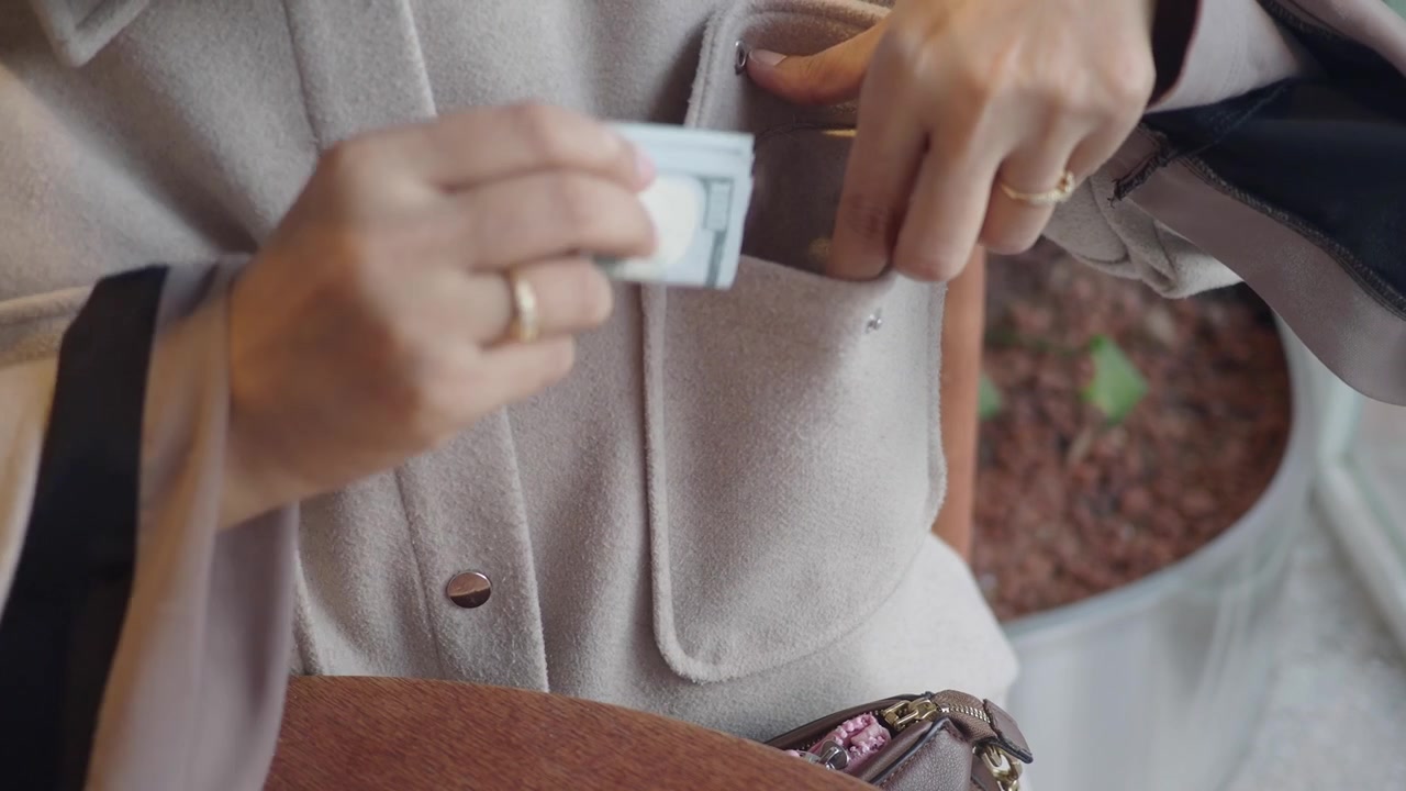 Person Putting Cash Into Jacket Pocket