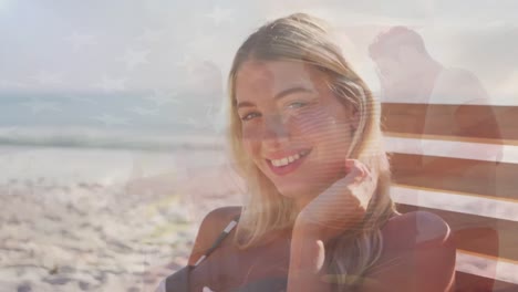 animación de la bandera de los estados unidos de américa sobre una mujer caucásica feliz en la playa