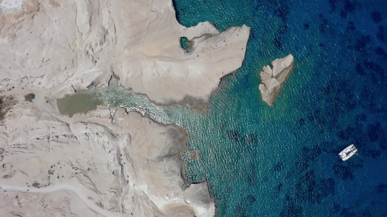 aerial: fotografía de arriba de la playa de sarakiniko en la isla de milos, grecia durante el mediodía