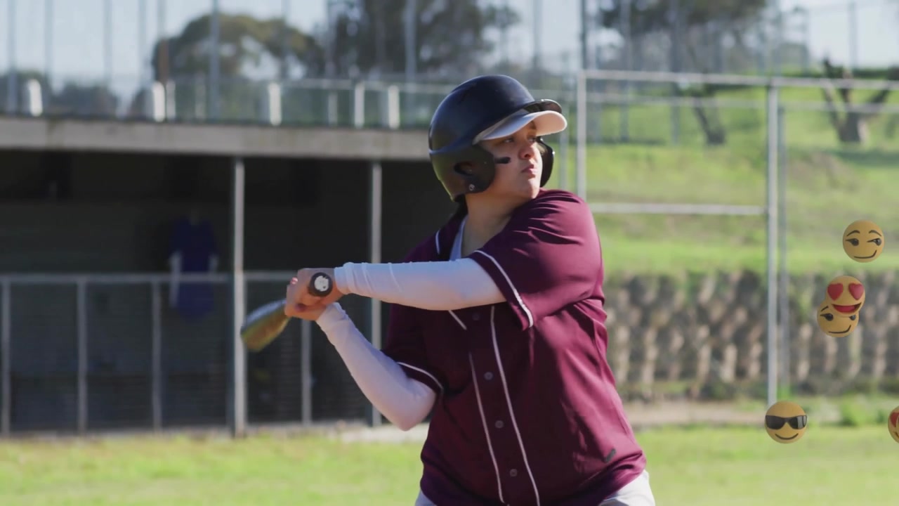 Battitore di baseball alla base che osserva il lancio, mentre emoji vorticano intorno al busto prima di oscillare per colpire.
