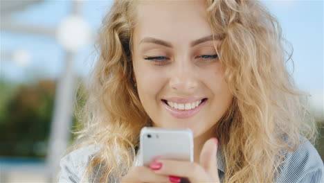 Porträt-Einer-Attraktiven-Jungen-Frau,-Die-Lächelnd-Auf-Den-Telefonbildschirm-Schaut