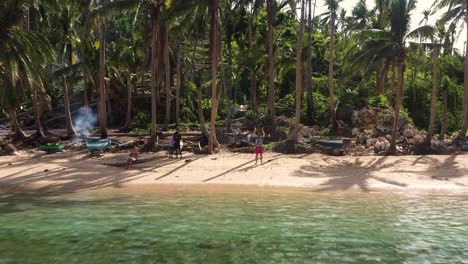 Male-Tourist-In-A-Philippine-Beach-Resort-Waves-At-Drone-Camera-Flying-Away