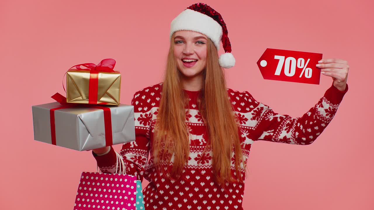 mujer con suéter de navidad mostrando caja de regalos y inscripciones de descuento del 70 por ciento nota de texto de banner