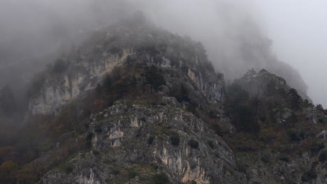 la niebla se eleva sobre los picos rocosos en un día de niebla, la niebla enigmática montañas escarpadas, abrazando el clima frío