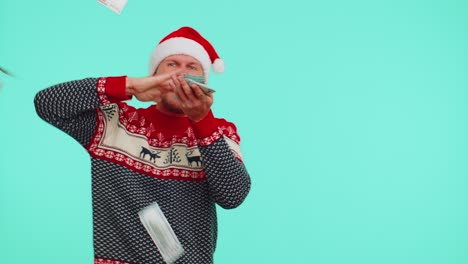 rich man winner in christmas red sweater and hat showing wasting, throwing money around, shopping