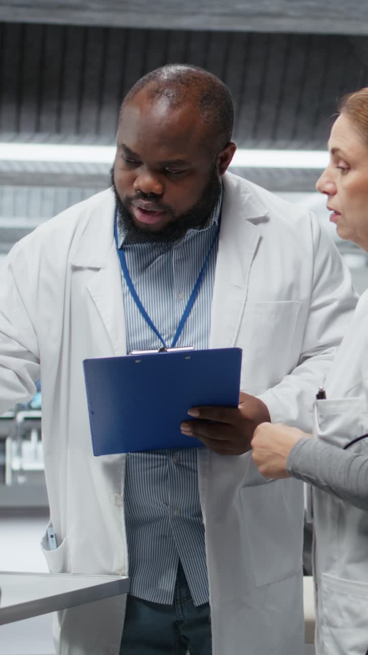 Vertical Video Two researchers testing patient during drug trial and recording side effects
