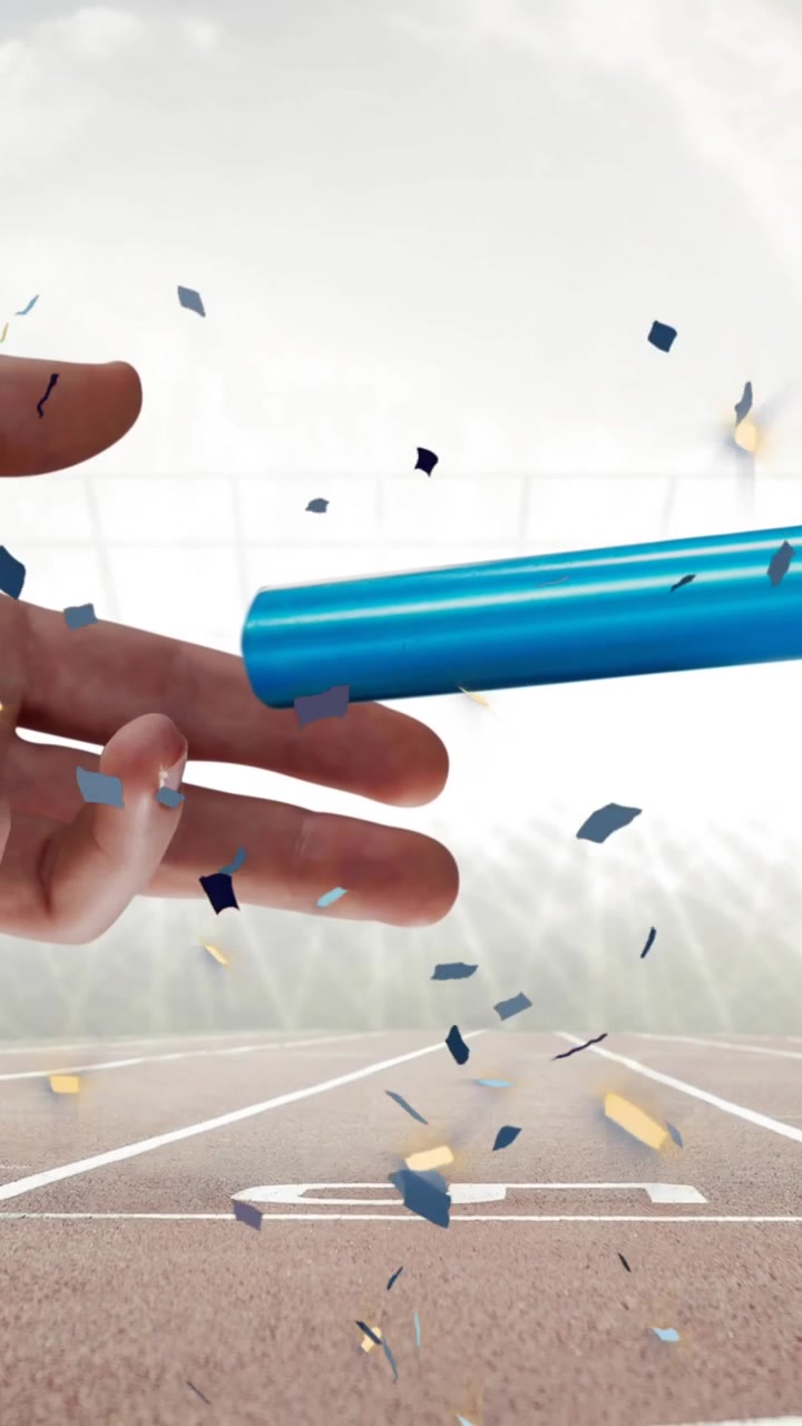 Confetti falling over close up of a hand passing a baton against sports field