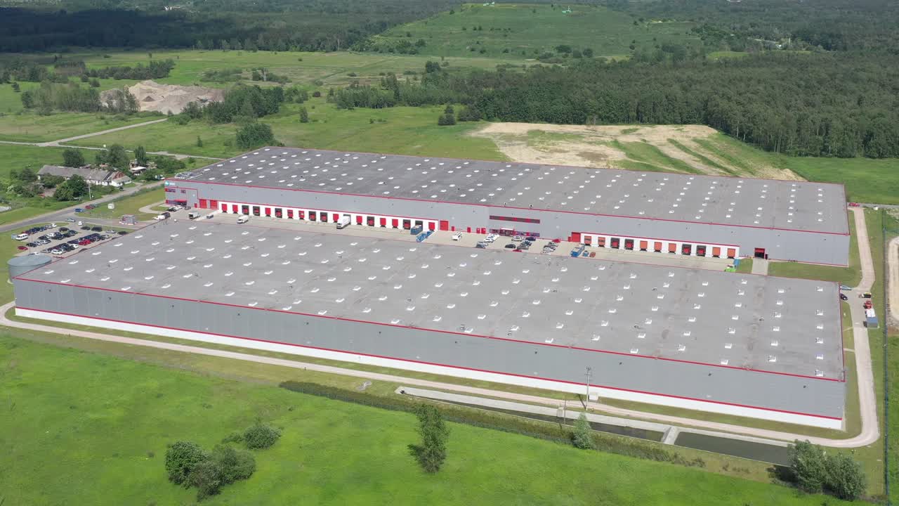 disparo lateral aéreo en movimiento del muelle de carga de almacén industrial donde muchos camiones con semirremolques cargan o descargan mercancía. disparo de cámara 4k uhd.