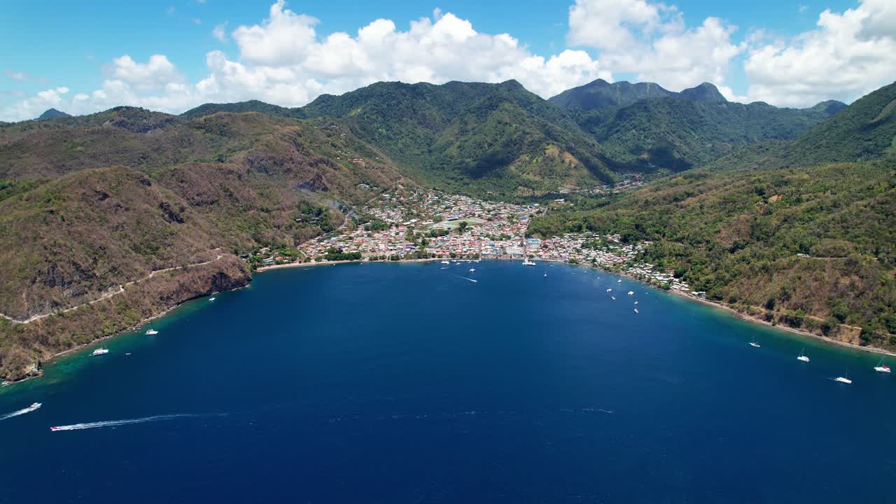 Aerial View Of Pitons Bay, St. Lucia On A Sunny Summer Day. The Drone Captures Lush Green Mountains, A Small City, And Yachts Floating In The Bay, Creating A Serene And Vibrant Atmosphere.