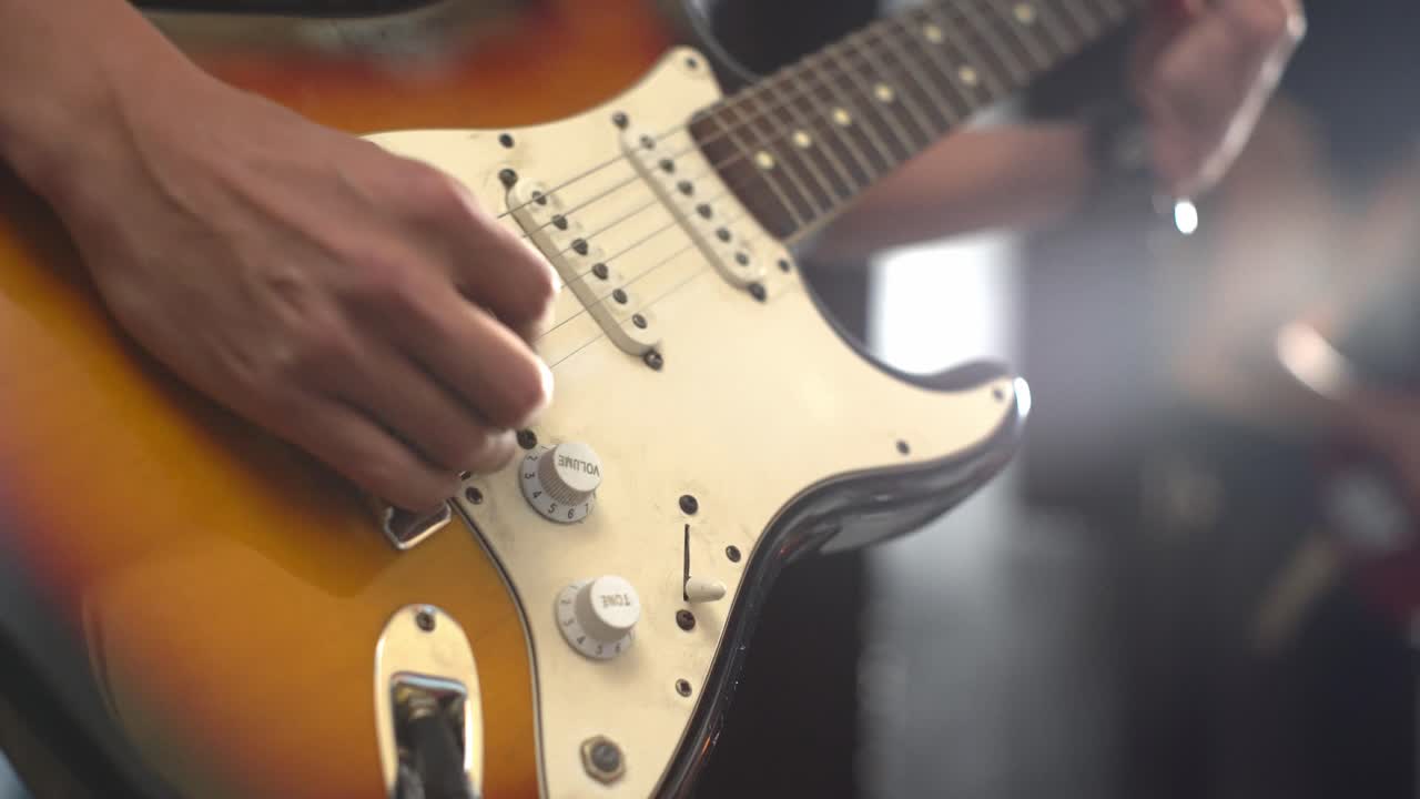 Elektro gitar çalan müzisyen. Yatay sinematik çekim