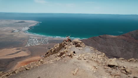 Aerial-view-of-couple-standing-on-the-cliff