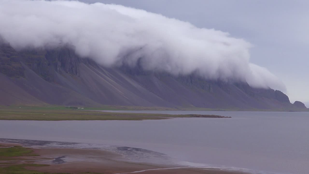 구름과 안개가 정상 1 위로 굴러가는 아이슬란드의 놀라운 아름다운 피요르드의 놀라운 저속 촬영
