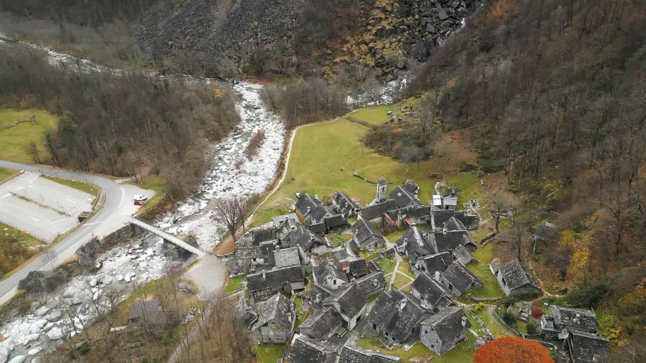 drone aéreo disparado desde arriba sobre casas de la aldea a lo largo del río maggia en cavergno, distrito de vallemaggia en el cantón de ticino, suiza en un día nublado
