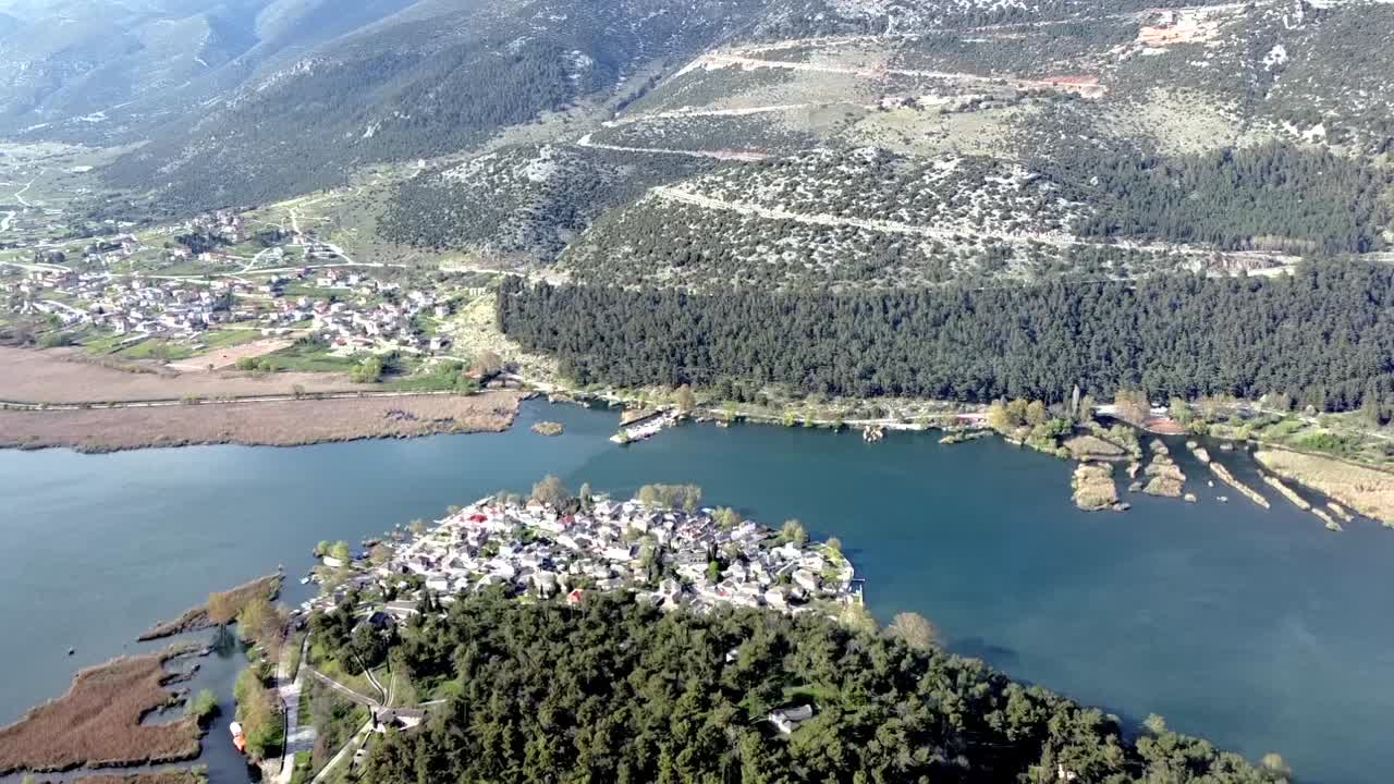 Kirkas ilmakuva dronella Ioanninan saaren perinteisen kivikylän yltä. Panoraamanäkymä kylästä, jota ympäröivät tyynet järvivedet kirkkaassa päivänvalossa Kreikassa