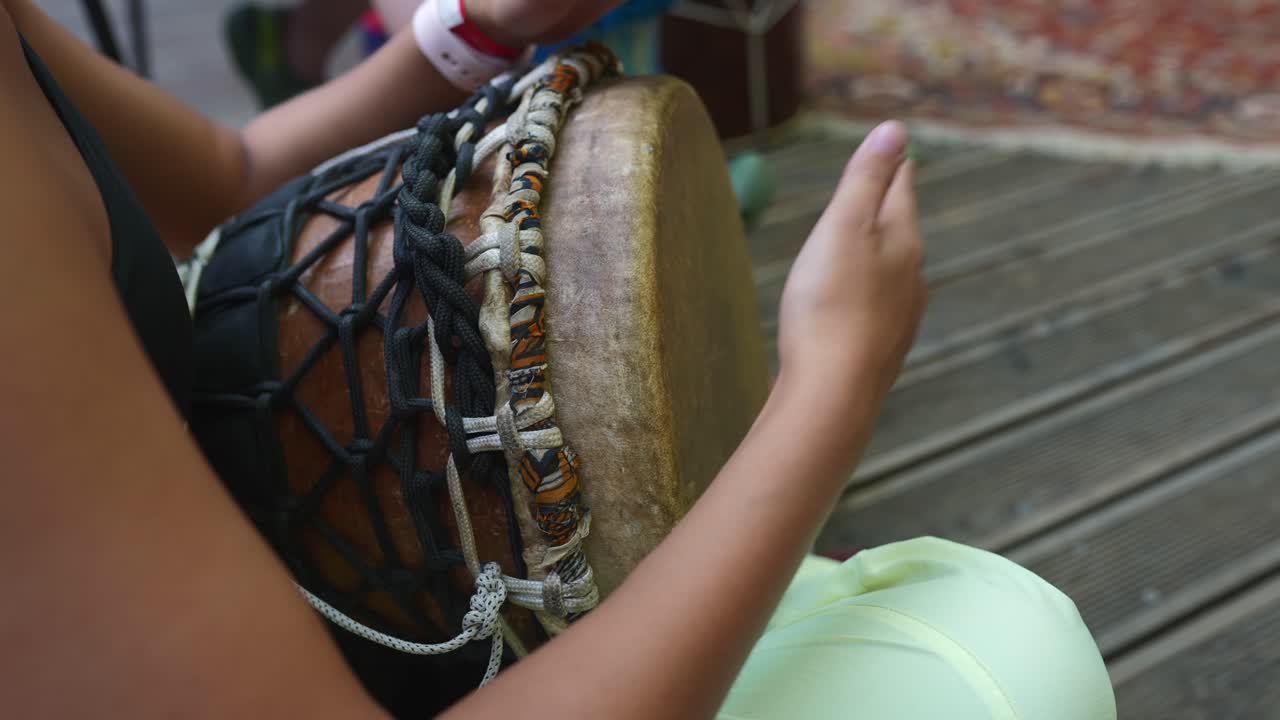 mujer tocando el tambor de djembe
