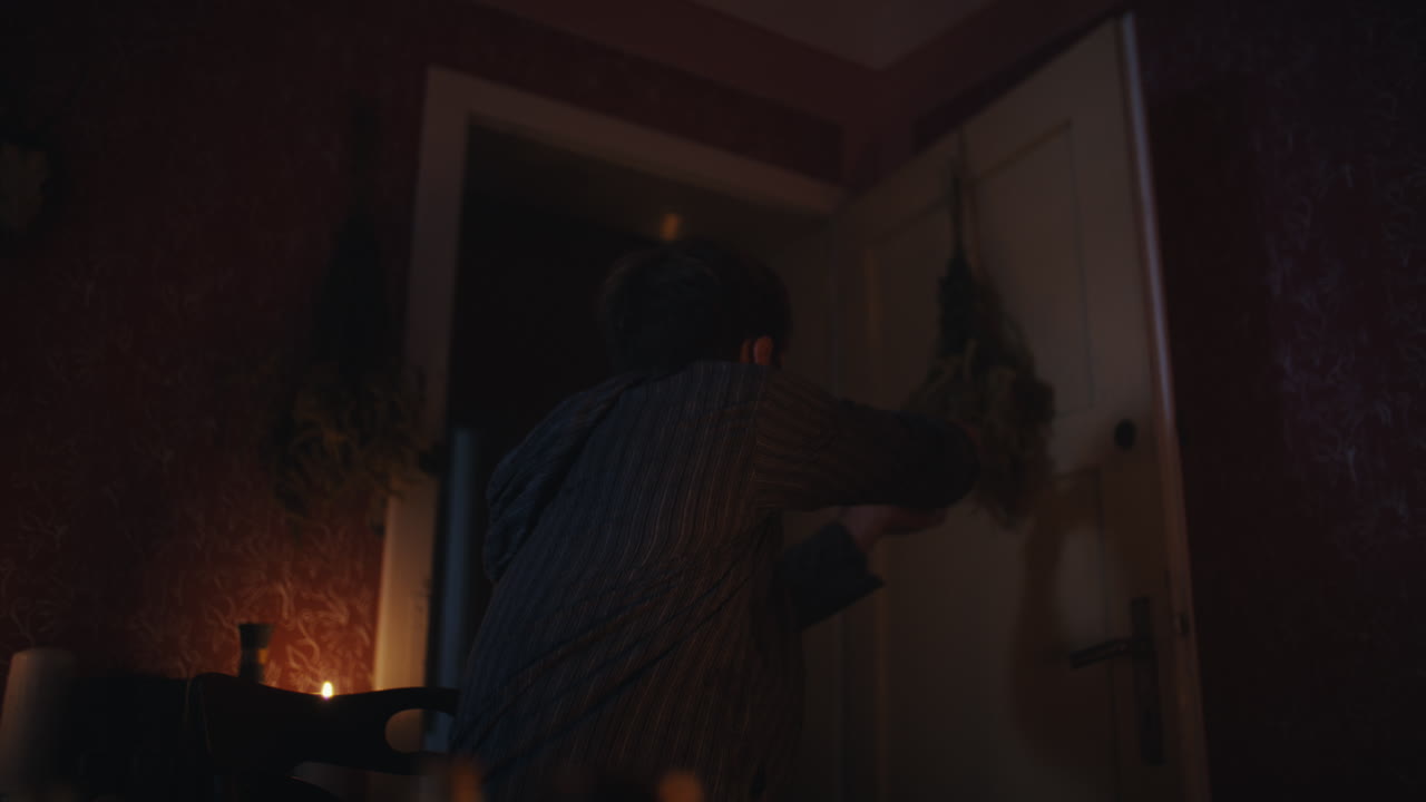 Man engaged in a mysterious ritual in a dimly lit room