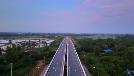 Aerial:-Drone-symmetrically-flying-forward-and-panning-down-above-a-Highway-early-in-the-morning