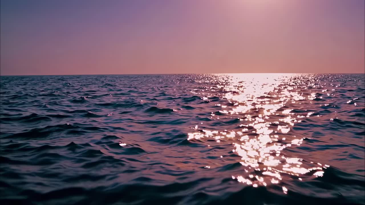 A serene ocean view at sunset, captured from a low-angle perspective, showcasing shimmering waves