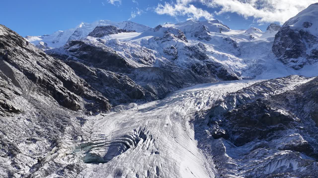 A panoramic view of the Upper Engadin valley. Golden larch forests meet snow-capped mountains and glaciers in a stunning display of high-altitude seasonal contrast