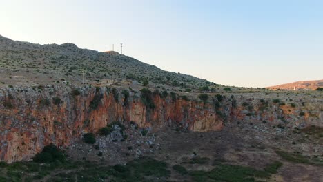 Crater-like-formation-in-the-province-of-Trapani-Sicily-Italy-near-the-city-of-Custonaci,-Aerial-drone-forward-ease-in