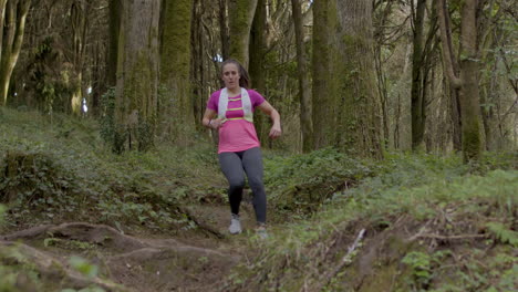 Mujer-Enfocada-En-Ropa-Deportiva-Corriendo-Por-Un-Sendero-Forestal