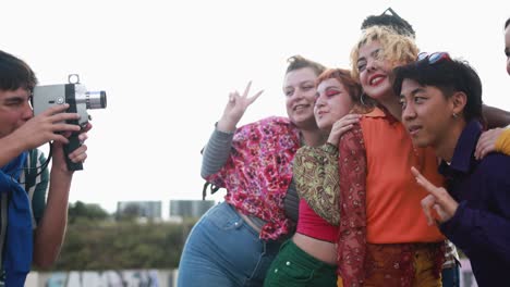 young diverse people having fun with old vintage video camera outdoor