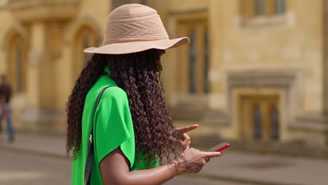 Turista-Femenina-Con-Cámara-De-Vacaciones-En-Oxford,-Reino-Unido,-Explorando-La-Ciudad-Caminando-Por-Holywell-Street-Usando-Un-Teléfono-Móvil-Para-Obtener-Direcciones-E-Información-5