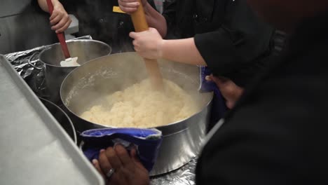 mixing dough in a pot and heating it up with a big wooden spoon.