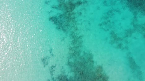 Aerial-Birds-Eye-View-Over-Reflective-Beautiful-Blue-Turquoise-Ocean-Waters