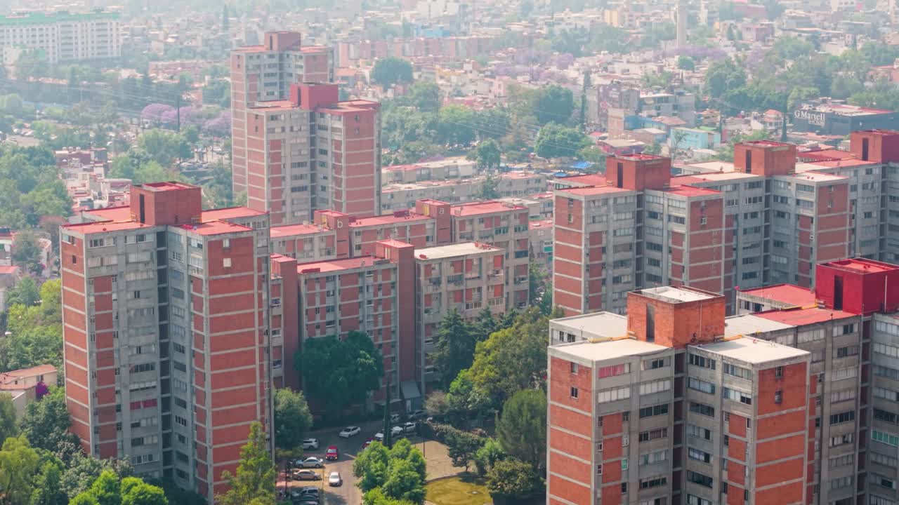 Scatto ad alta quota di edifici residenziali rossi nel sud di CDMX con foschia