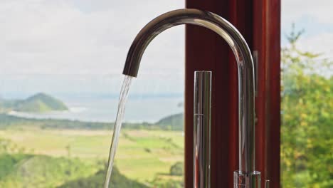 luxury tap ware in hotel bathroom with ocean views in the background