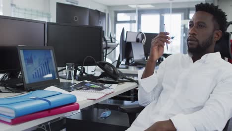 Thoughtful-man-sitting-on-his-desk-in-office