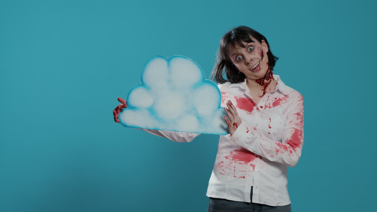 Creepy zombie woman holding cardboard cloud art while standing on blue background