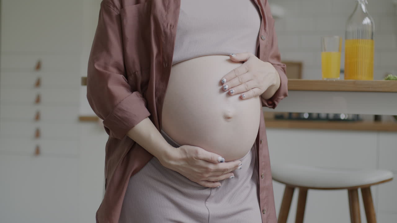 беременная женщина держит свой живот